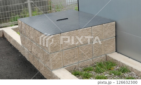 金属の蓋をした駐車場内にある古井戸 126632300