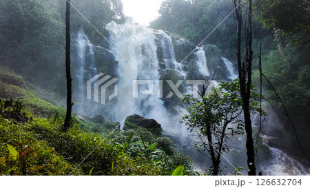 The nature of the waterfall in the forest that flows strongly during the rainy season. Strong current in the river, waters turned muddy after heavy rains in autumn. The nature of the waterfall in the forest that flows strongly during the rainy season. Strong current in the river, waters turned muddy after heavy rains in autumn. 126632704