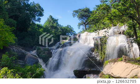 The nature of the waterfall in the forest that flows strongly during the rainy season. Strong current in the river, waters turned muddy after heavy rains in autumn. The nature of the waterfall in the forest that flows strongly during the rainy season. Strong current in the river, waters turned muddy after heavy rains in autumn. 126632705