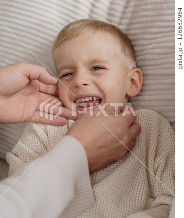 Close-up of a 4-year-old boy's face laughing from tickling his dad at home on the couch. High quality photo 126632964