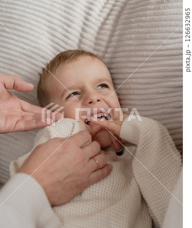 Close-up of a 4-year-old boy's face laughing from tickling his dad at home on the couch. High quality photo 126632965