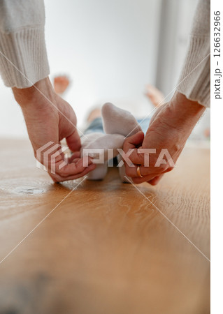 A dad holds his 4-year-old son's feet in his socks and tickles them. High quality photo 126632966