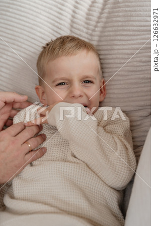 Close-up of a 4-year-old boy's face laughing from tickling his dad at home on the couch. High quality photo Close-up of a 4-year-old boy's face laughing from tickling his dad at home on the couch. High quality photo 126632971