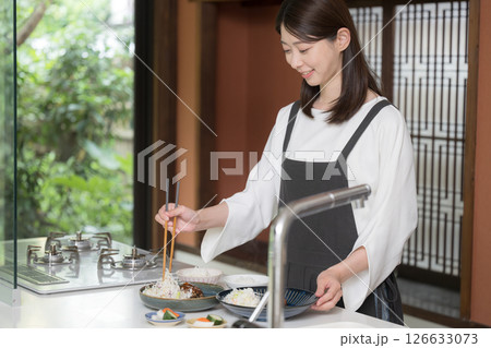 食事を準備するエプロンを着た女性 126633073