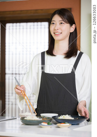 食事を準備するエプロンを着た女性 126633083