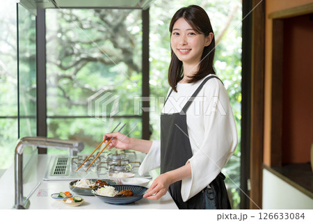 食事を準備するエプロンを着た女性 126633084