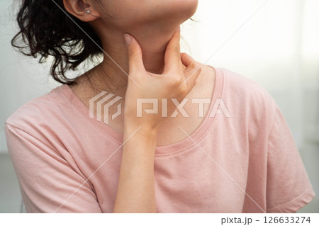 Asian woman touching her neck and throat for thyroid gland problem. Asian woman touching her neck and throat for thyroid gland problem. 126633274