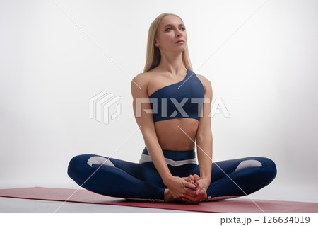 Woman practicing yoga in a studio setting focused on balance and flexibility 126634019