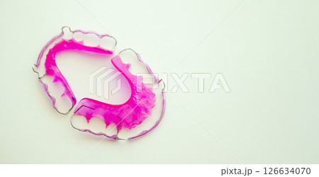 Pink acrylic dental retainer on white background 126634070