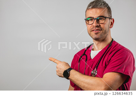 Doctor in scrubs points to empty space in clinic during consultation Doctor in scrubs points to empty space in clinic during consultation 126634635