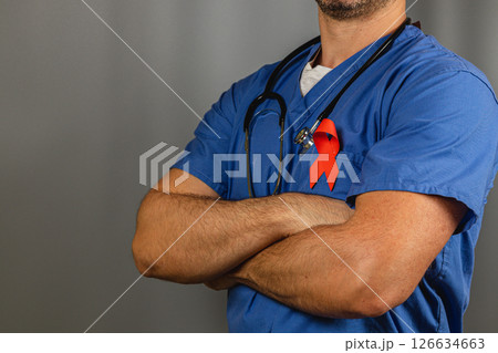 Health professional wears red ribbon promoting awareness in clinic Health professional wears red ribbon promoting awareness in clinic 126634663