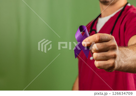 Healthcare worker with a purple ribbon for cancer research support Healthcare worker with a purple ribbon for cancer research support 126634709
