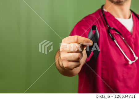 Healthcare worker holds black ribbon to raise awareness in a hospital 126634711