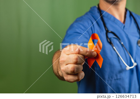 Healthcare worker holds orange ribbon to raise awareness for cancer support 126634713