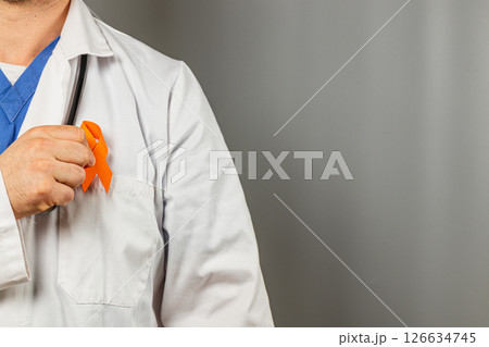 Healthcare professional displays orange ribbon for awareness campaign Healthcare professional displays orange ribbon for awareness campaign 126634745