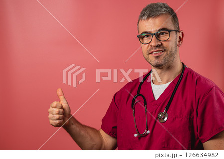 Confident doctor giving a thumbs up in a clinical setting Confident doctor giving a thumbs up in a clinical setting 126634982