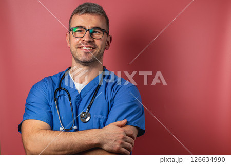 Confident healthcare professional smiling with arms crossed in studio 126634990