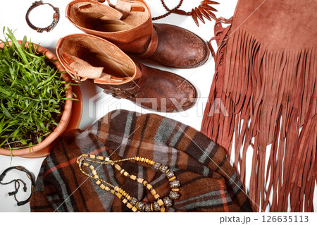 Boho Style. Leather Boots, Wooden Necklace, Denim Shorts and Hippie Bag with Fringe on White Background. Overhead View of Woman's Casual Day Outfits. Trendy Hipster Look. 126635113