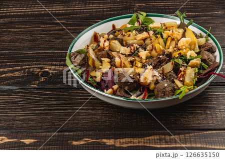 Savory salad with grilled vegetables and meat on wooden table 126635150
