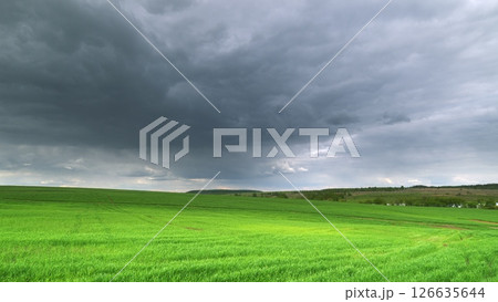 Gloomy Skies Hovering Above Lush Green Fields That Stretch Far and Wide Into the Horizon Time lapse. Gloomy Skies Hovering Above Lush Green Fields That Stretch Far and Wide Into the Horizon Time lapse. 126635644