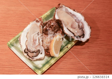 close up of three raw uncooked oyster in shell on a plastic container with copy space 126638314