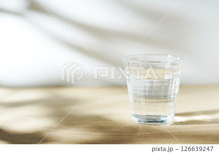 陽ざしの当たったテーブルに置かれた冷たい水 126639247