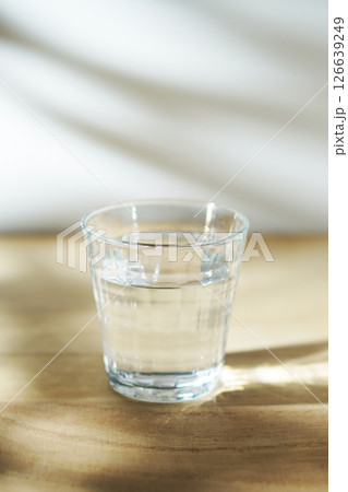 陽ざしの当たったテーブルに置かれた冷たい水 126639249