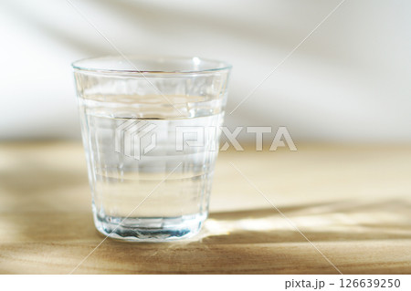 陽ざしの当たったテーブルに置かれた冷たい水 126639250