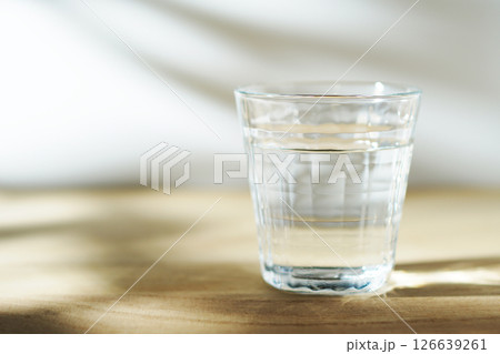 陽ざしの当たったテーブルに置かれた冷たい水 陽ざしの当たったテーブルに置かれた冷たい水 126639261