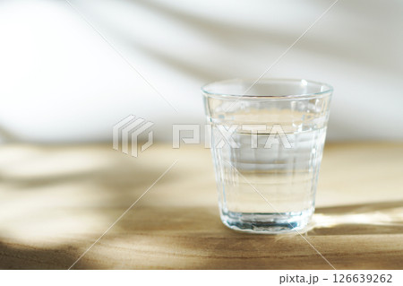 陽ざしの当たったテーブルに置かれた冷たい水 126639262