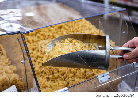 Pasta selection in a grocery store with a scoop for customers to choose their favorite types Pasta selection in a grocery store with a scoop for customers to choose their favorite types 126639284