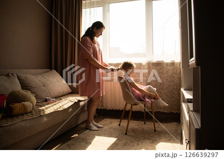 Mother daughter morning routine. Mother brushes and braids her preschooler hair before daycare. Real life parenting Mother daughter morning routine. Mother brushes and braids her preschooler hair before daycare. Real life parenting 126639297