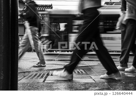 雨の街を歩く人々と走り去るバス(モノクロ) 雨の街を歩く人々と走り去るバス(モノクロ) 126640444