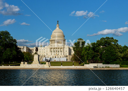 Visitors enjoy sunny day at U.S. Capitol reflecting in water surrounded by trees in Washington DC. Visitors enjoy sunny day at U.S. Capitol reflecting in water surrounded by trees in Washington DC. 126640457