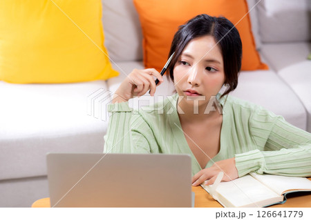 Young asian woman planning and strategy about finance and investment or tax while thoughtful. Young asian woman planning and strategy about finance and investment or tax while thoughtful. 126641779
