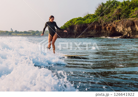 Surf girl on surfboard riding on wave in Bali. Surf girl on surfboard riding on wave in Bali. 126641922