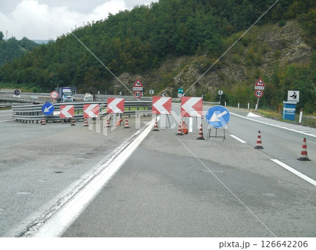 Road with a lot of orange cones and signs 126642206