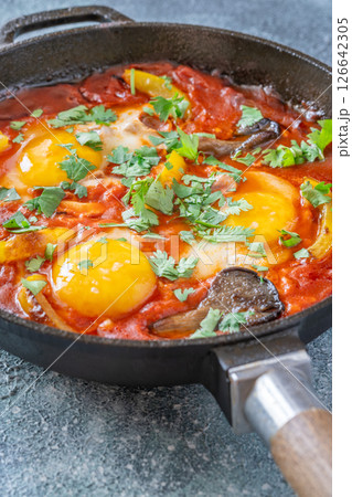 Shakshuka with mushrooms and yellow peppers topped with eggs and cilantro Shakshuka with mushrooms and yellow peppers topped with eggs and cilantro 126642305