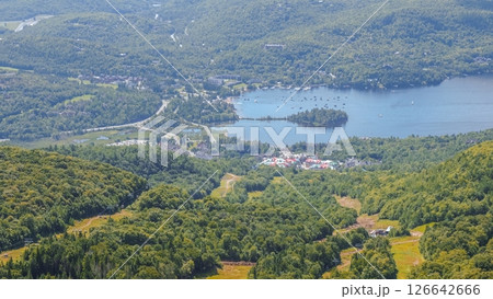 Aerial View of a Charming Mountain Town Surrounded by Lush Green Peaks and a Serene Lake Aerial View of a Charming Mountain Town Surrounded by Lush Green Peaks and a Serene Lake 126642666