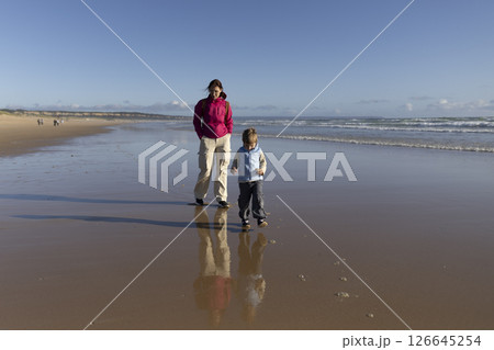 Mother and son walking on the beach at low tide 126645254