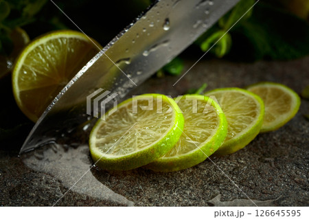 Knife, slices of lime and sprigs of fresh mint. 126645595
