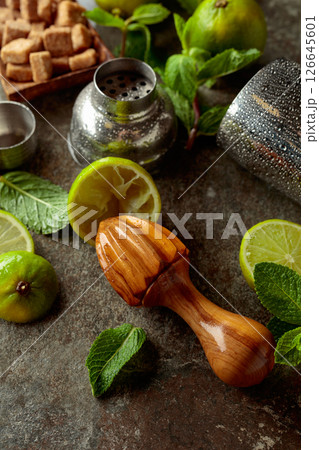 Wooden citrus squeezer, shaker, and ingredients for making summer refreshing drinks. Wooden citrus squeezer, shaker, and ingredients for making summer refreshing drinks. 126645601