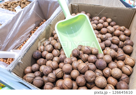 Unpeeled macadamia nuts are sold in a grocery store 126645610