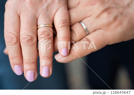 Married mature old couple holding hands with rings ceremony wedding day Married mature old couple holding hands with rings ceremony wedding day 126645647