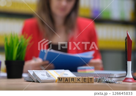 A dedicated businesswoman engaged in analyzing current market trends within a modern office setting A dedicated businesswoman engaged in analyzing current market trends within a modern office setting 126645833