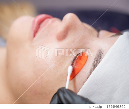 Caucasian woman undergoing eyelash lamination procedure.  126646862