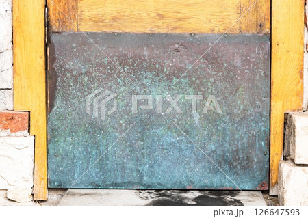 copper plate closes hole in outdoor door close up 126647593