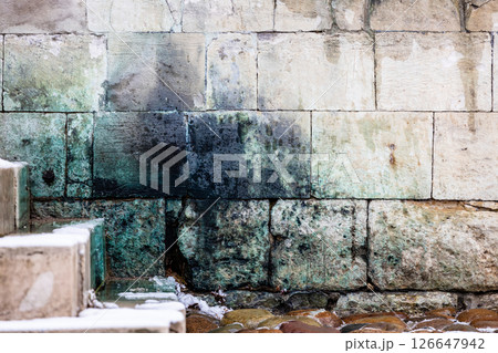 lichen covered stone wall and steps in monastery 126647942