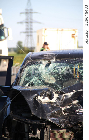 A crumpled hood, a broken windshield and deployed airbags in a car after an accident A crumpled hood, a broken windshield and deployed airbags in a car after an accident 126648433