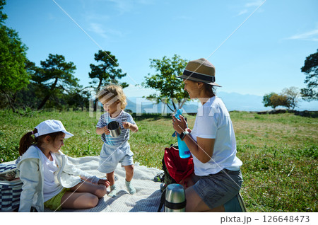 Family Enjoying a Relaxing Picnic in Nature During a Sunny Day 126648473